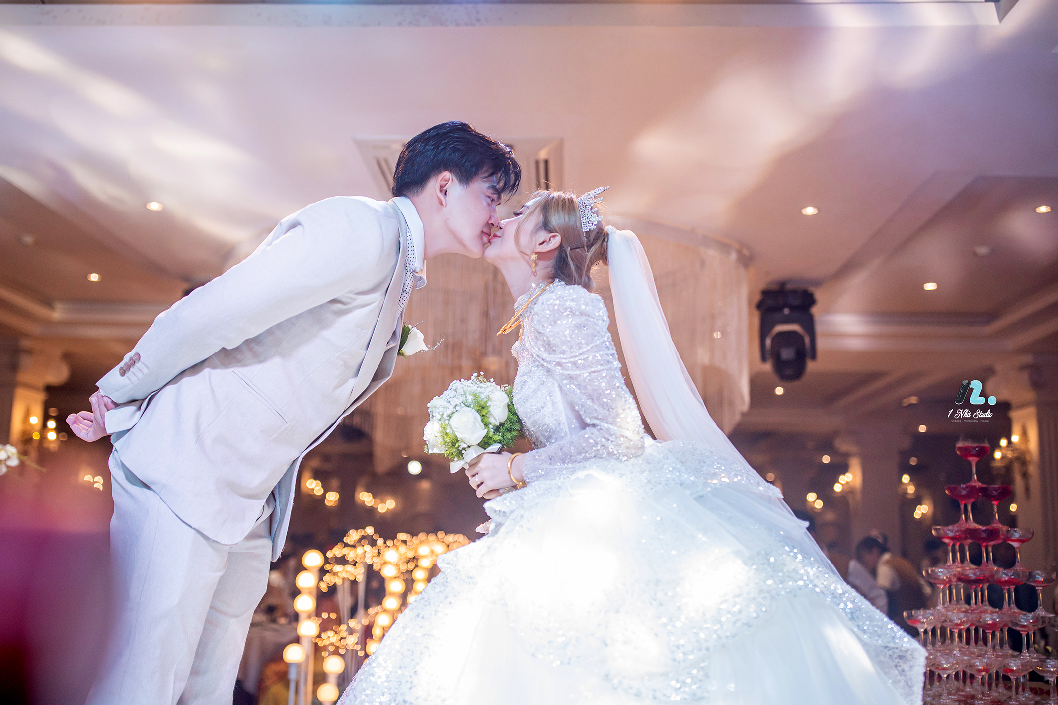 Nụ hôn ngọt ngào của dâu rể bên tháp rượu champagne trong nghi thức tiệc cưới ngày trọng đại